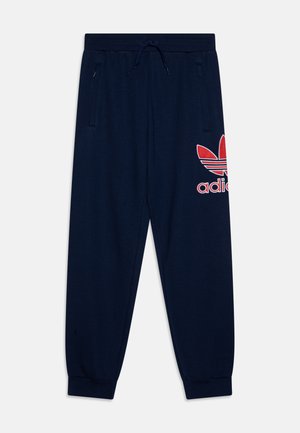Pantaloni sportivi bleumarin cu talie elastică, sistem de închidere cu șnur, două buzunare laterale și un logo roșu și alb adidas pe coapsa stângă.