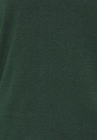 Mörkgrön stickad tyg med en slät struktur, som har ett enhetligt vävmönster och inga synliga dekorationer eller sömmar.