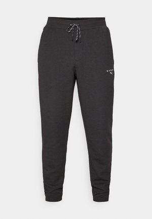 Zwarte joggingbroek van zacht materiaal, met een trekkoord in de taille, boorden aan de enkels en een klein logo aan de onderzijde.