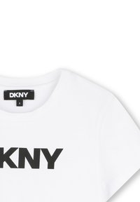 Witte katoenen t-shirt met een ronde halslijn en korte mouwen, versierd met vetgedrukte zwarte "DKNY" tekst over de borst.
