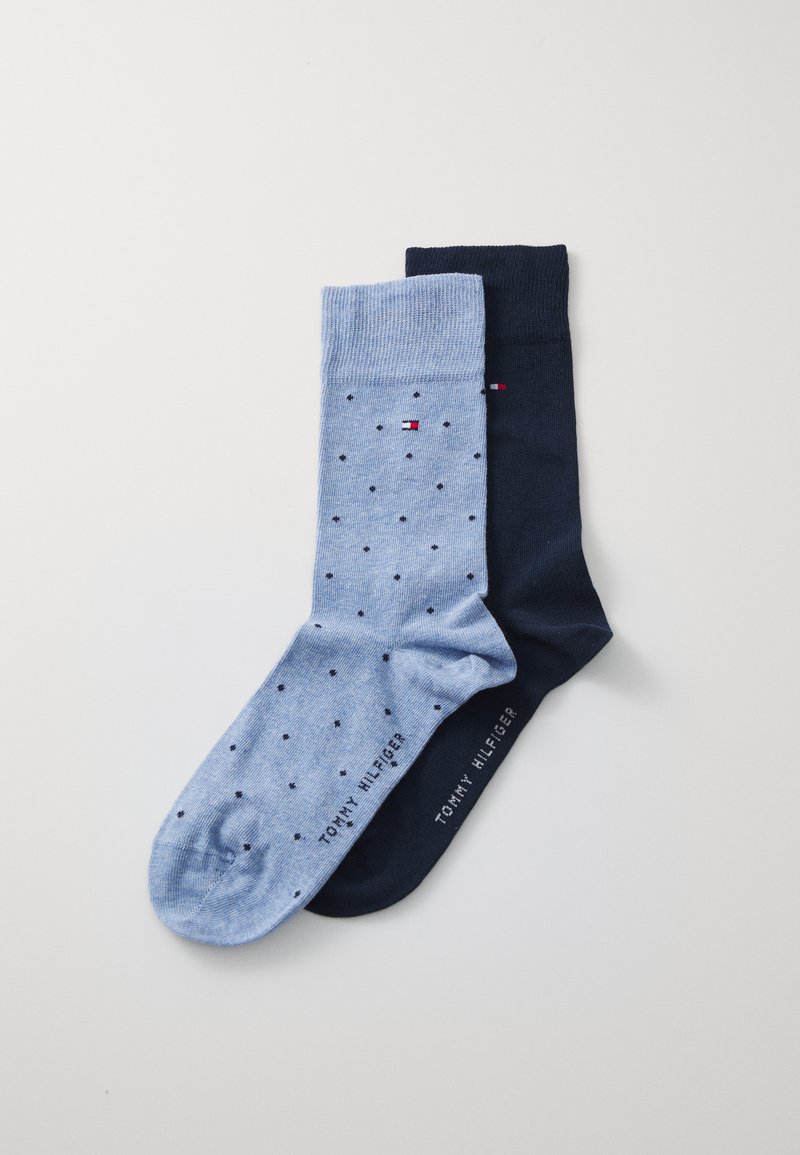 Zwei Paar Socken: ein hellblaues mit Punkten und ein einfarbiges marineblaues. Beide haben einen gerippten Bund und ein Logo an der Unterseite.