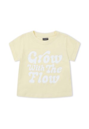 Camiseta para niño pequeño de color amarillo claro con mangas cortas y texto blanco que dice "Crece con el flujo" en el frente.