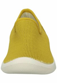 Botte jaune à enfiler avec une tige en tricot, bout rond et semelle en caoutchouc blanc avec un motif de grip texturé. Pas d'accents matériels visibles.