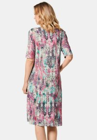 Multikleurige jurk met een paisley- en abstract patroon, korte mouwen, knie-lange snit en een zachte, vloeiende stoftextuur.