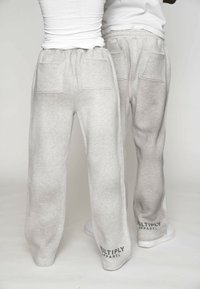 Jasnoszare spodnie dresowe o miękkiej fakturze, elastycznym pasku w talii i dwóch kieszeniach z tyłu. Logo "MULTIPLY APPAREL" nadrukowane w pobliżu dołu.