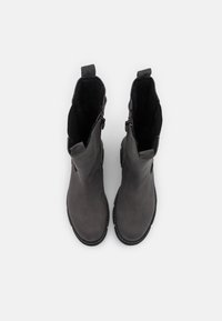 Stivaletti grigi in pelle liscia con rivestimento nero texturizzato, dotati di cerniere laterali e suola in gomma per una migliore aderenza.