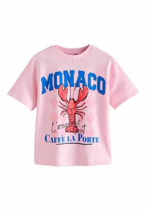 Rózsaszín rövid ujjú póló kék "MONACO" felirattal, piros homár grafikával és francia kifejezésekkel: "L'amour est tout" és "Caffè La Porte" az elején.