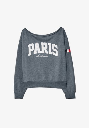 Donkergrijze sweatshirt met "PARIS" in grote witte letters, "Le Marais" in kleinere schrift eronder, en een kleine Franse vlag op de linkermouw.