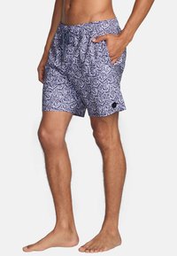 Navy blue swim shorts with white rose pattern, elastic waistband, drawstring, and side pockets. Lightweight fabric with a relaxed fit.