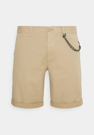 Beige Baumwollshorts mit umgeschlagenen Säumen, Knopfverschluss und einem dekorativen Seildetail an der Tasche. Glatte Textur, legeres Design.