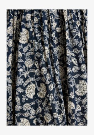 Material bleumarin cu un model floral alb, având diverse flori și frunze dispuse într-un design repetitiv cu pliu.