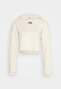 Beskuren krämfärgad hoodie med dragsko i huvan, ribbade muddar och en liten logotypapplikation på framsidan. Mjuk tygkvalitet, avslappnad passform.