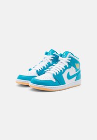 High-top sneakers featuring a white base with turquoise overlays, white laces, a gum sole, and gold logo accents on the side.