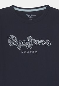 Navy blue t-shirt with round neckline featuring white outlined "Pepe Jeans" logo and "London" text centered on the chest.