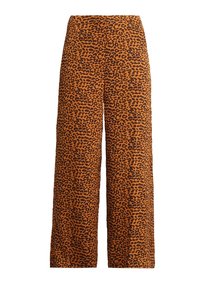 Löysät housut, joissa on oranssi ja musta leopardikuvio, valmistettu liukkaasta kankaasta, korkealla vyötäröllä ja ilman näkyvää varustusta.