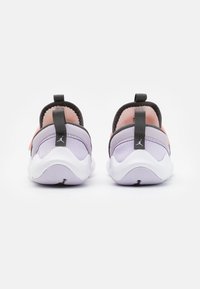 Pár pastelově fialových a růžových slip-on tenisek s černými poutky a bílými podrážkami, zobrazených zezadu na bílém pozadí.