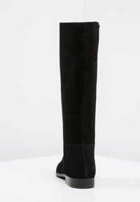 Czarne zamszowe botki za kolano o gładkiej fakturze, dopasowanym kształcie i niskim obcasie, bez widocznych elementów metalowych ani ozdób.