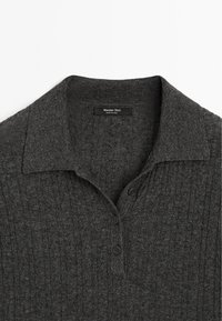 Polo en maille gris charbon avec col, présentant une texture côtelée, deux boutons et une petite étiquette indiquant "Massimo Dutti".