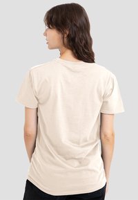 Beige cotton t-shirt with a rounded neckline and short sleeves. Soft texture, standard fit, plain back view, no visible graphics or patterns.