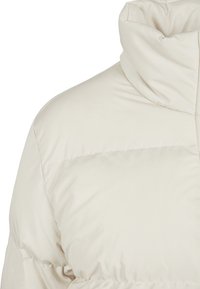 Lys beige dunjakke med høj krave, glat tekstur og quiltet design. Har en strømlinet silhuet og subtil glans.