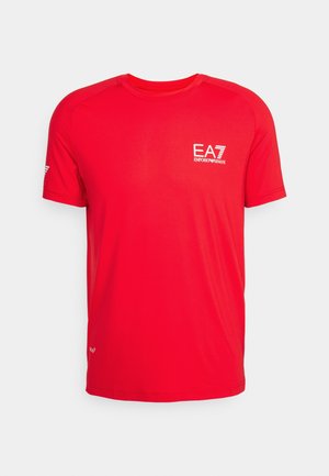 Červené sportovní tričko s krátkým rukávem vyrobené z lehkého materiálu. Má kulatý výstřih, texturovaný povrch a bílé logo EA7 na hrudi.