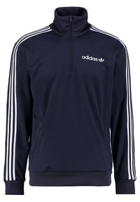 Chaqueta pullover navy con cuello alto, con un zipper de cuarto, acentos en blanco con tres franjas en las mangas y un logo en el pecho.