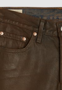 Bruine denim jeans met een klassiek ontwerp van vijf zakken, koperen hardware accenten en een subtiele textuurafwerking.