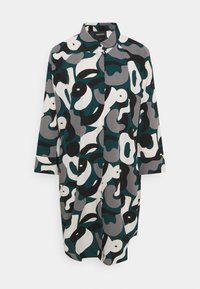 Chemise à boutons dans un tissu léger, présentant un motif abstrait audacieux de formes vert foncé, gris, noir et blanc. Manches trois quarts.