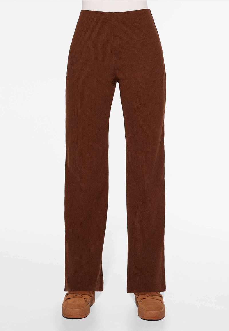 Bruine geribbelde flared broek met een hoge taille en zijsplitten aan de zoom. Gemaakt van een gestructureerde stof, met een gladde afwerking en een gelijkmatige snit.