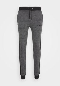 Grå rutiga sweatpants med svart midjeband och sidodetaljer, utrustade med elastiskt snörning och ankle cuffs.