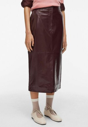 Jupe midi en simili cuir bordeaux avec une texture en imprimé serpent, arborant une silhouette ajustée et une longueur arrivant au genou. Fini lisse et brillant.