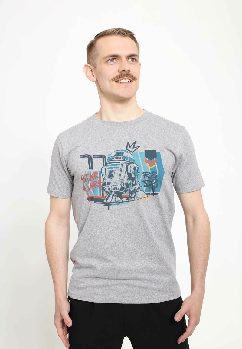 Camiseta gris de manga corta con un gráfico colorido de un droide y el texto "Star Wars" junto a formas abstractas, fabricada en suave material de algodón.