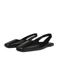 Zapatos slingback de cuero negro con punta cuadrada, suela plana y diseño minimalista. Textura suave y tiras delgadas en el tobillo.