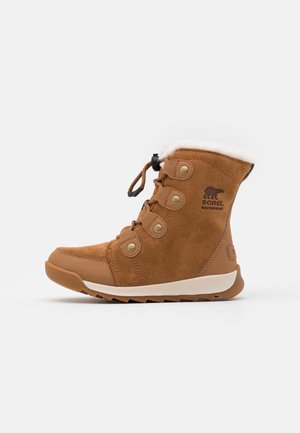 Botte d'hiver en suède marron imperméable, doublure en fourrure blanche, œillets métalliques ronds, lacets noirs et semelle légèrement crantée, logo latéral visible.