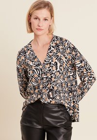 Zwart-wit gebloemd blouse met oranje accenten, V-hals, lange mouwen en een relaxte pasvorm; textuurstof met botanisch ontwerp.