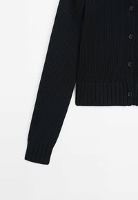 Marineblauwe gebreide cardigan met een gestructureerde stof, lange mouwen en een geribde zoom, voorzien van zes zwarte knopen aan de voorkant.