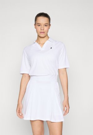 White athletic polo shirt with short sleeves and a collared neck, paired with a matching flared skirt. Features subtle branding on the chest.