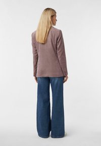 Getailleerde, lichtpaarse corduroy blazer met een gladde textuur en lange mouwen, gecombineerd met hooggewaadde, wijde blauwe jeans.