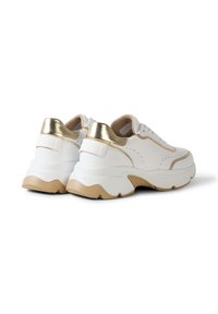 Nízké tenisky v bílé a zlaté barvě s masivními béžovými podrážkami, šněrováním a kovovými zlatými detaily na patě, zobrazené zezadu a z boku.