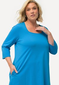 Bla dresses mit drei Viertelärmeln, aus weichem Stoff, mit einem runden Halsausschnitt und seitlichen Taschen für Praktikabilität und Komfort.