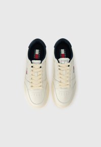 Κρέμα δερμάτινα αθλητικά παπούτσια με μπεζ κορδόνια, στρογγυλή μύτη, perforated λεπτομέρειες, ναυτικό εσωτερικό και μια μικρή ετικέτα λογότυπου στη πλευρά.