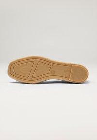 Semelle en caoutchouc avec motif de grip texturé, présentant une surface beige lisse et une forme arrondie. Bords renforcés pour plus de durabilité.