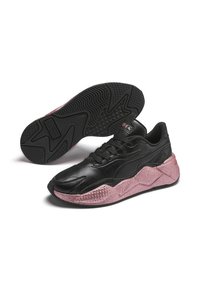 Zapatillas negras con una suela texturizada y brillante en color rosa. Tienen una parte superior suave, punta redondeada, cordones y una suela de goma con un dibujo en relieve.