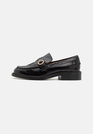 Mustad nahast loafers, millel on läikiv viimistlus, kaunistatud dekoratiivse ovaalse pandlaga ja madala plokk-kandiga. Klassikaline disain, millel on õmmeldud detailid.