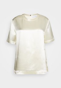 Top corto in satin crema a maniche corte con scollatura rotonda e spacco laterale. Texture liscia e leggero lucido, dotato di chiusura con zip sul retro.