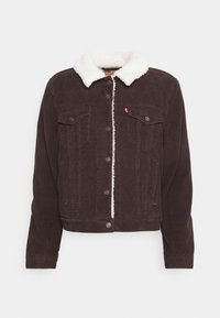 Giacca di velluto a coste marrone con colletto e rivestimento in sherpa bianco, chiusura con bottoni, due tasche a filetto sul petto e tasche laterali.