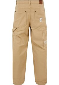 Khaki cargo-housut rentoa istuvuutta, joissa on takataskut, sivutaskut ja logo-aksentti. Valmistettu kestävästä puuvillakankaasta.
