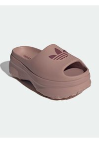 Helle pinke Rutschsandale mit offener Zehenpartie, dicke Sohle, strukturiertem Obermaterial und eingeprägtem Drei-Streifen-Logo auf der Vorderseite.