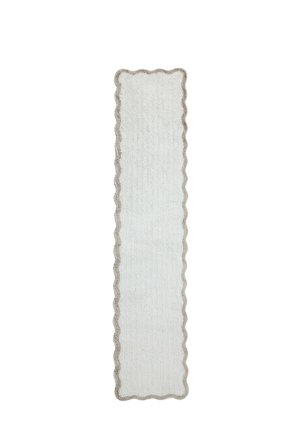 Striscia lunga e stretta di tessuto bianco con bordi smerlati e un bordo marrone chiaro su uno sfondo bianco uniforme.