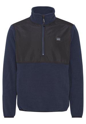 Jūrinė poliesterio megztinis su juodu nailono krūtinės paneliu, ketvirtiniu užtrauktuku, iškilniu apykakle ir šoninėmis kišenėmis. Turtinga logotipo etikete ant krūtinės.